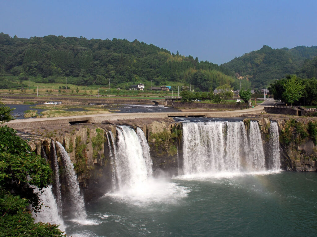 上方から見下ろした原尻の滝と周囲の山々。水の神への祈りと、五穀豊穣を願った人々の信仰を感じさせる風景