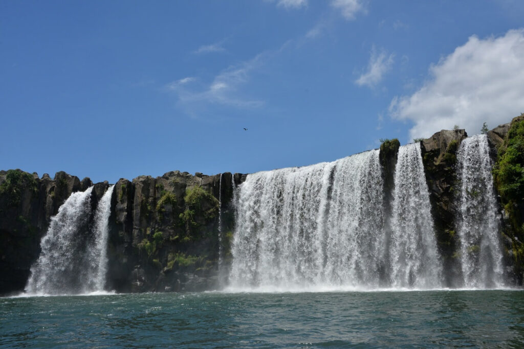 右下から見上げた原尻の滝。空を大きく取り入れ、滝に神が宿ると信じられてきた神聖な雰囲気が伝わる景観