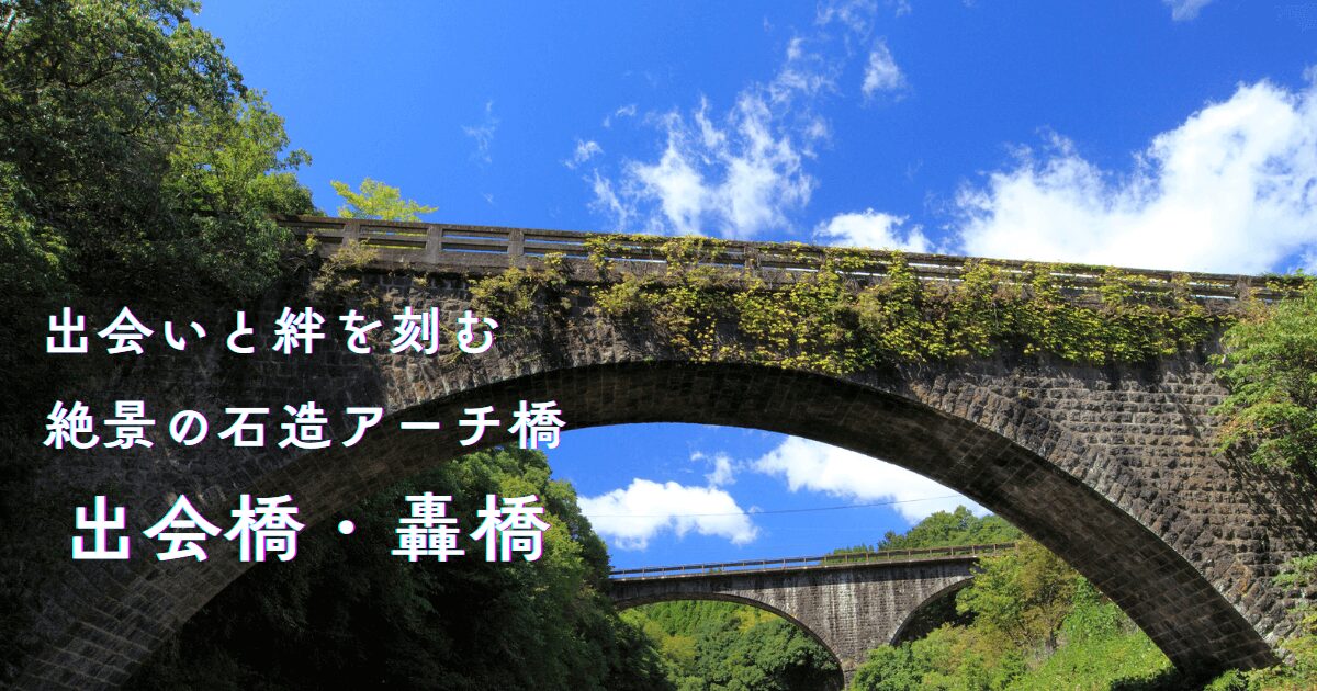 出会橋を中心に、奥に轟橋が見える奥嶽川の渓谷風景。青空の下、二つの石造アーチ橋が織りなすロマンあふれる絶景