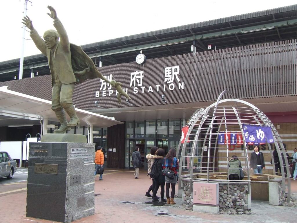 油屋熊八の像と別府駅前の様子