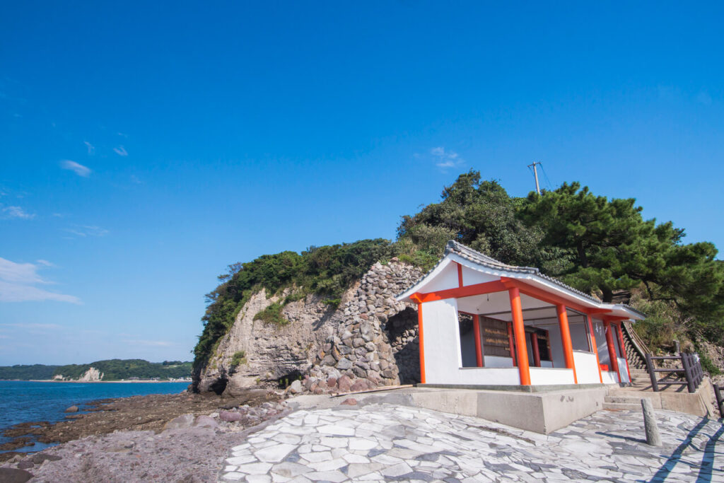 青空の下の粟島神社と青い海。開放感のある美しい景色。