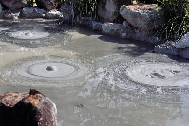 灰色の熱泥が3か所で泡立つ鬼石坊主地獄の様子