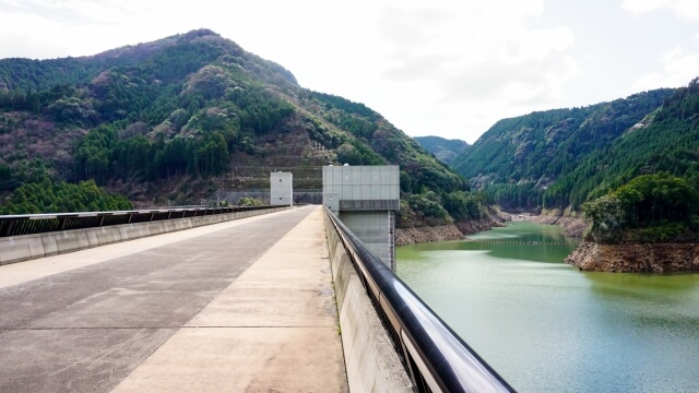 大山ダムの堤頂（ダムの最上部）から眼下に見下ろす、日田の大自然へと美しく続く阿蘇野川の流れ