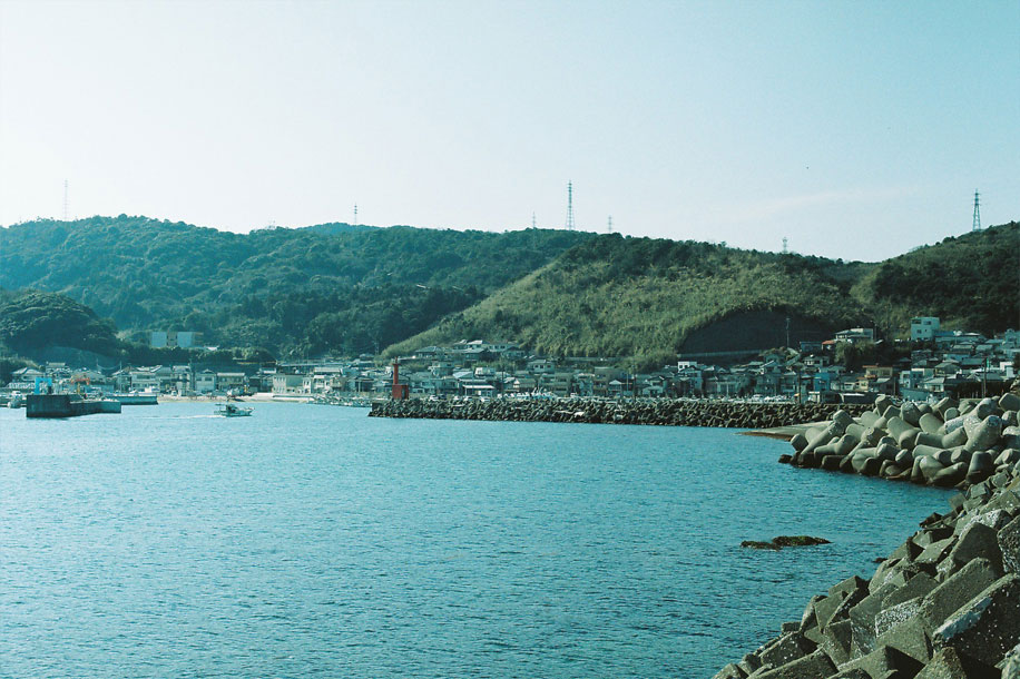 佐賀関の海の向こうに港町と山が見える風景