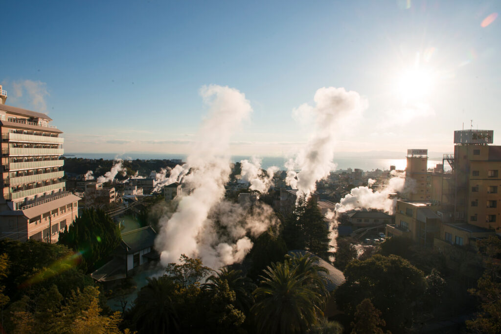 湯煙に包まれた別府の街並みと別府湾の眺め