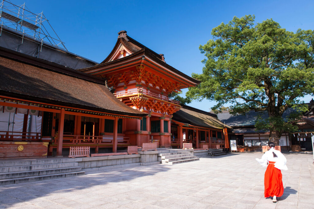 宇佐神宮 上宮の本殿全景と参道を歩く巫女の後ろ姿｜八幡信仰発祥の地・国宝建築