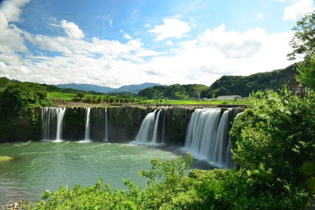 雄大な空と山々を背景に流れ落ちる原尻の滝。自然への畏敬と、水を荒らすと災いが起こると伝えられてきた信仰の地