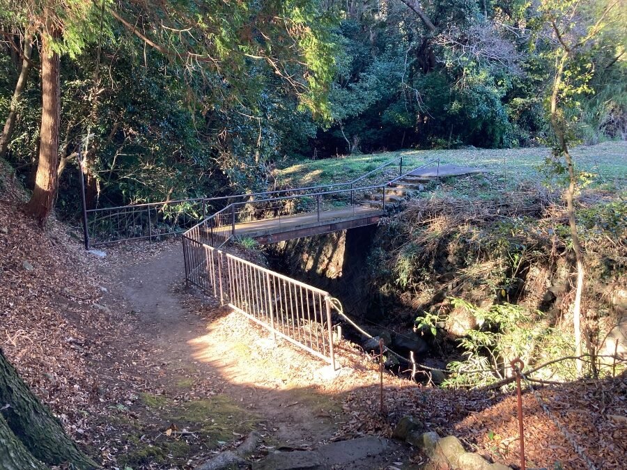 境内東側から宮川を渡る木橋。簡素な柵が架かる